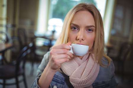 Ragazza sorseggia un espresso al bar