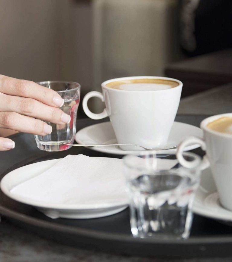 Caffè in tazzina servito con bicchiere di acqua